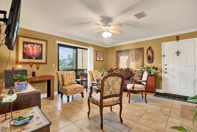 living area featuring light tile patterned floors, visible vents, baseboards, ceiling fan, and crown molding