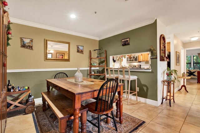 dining area featuring ornamental molding, baseboards, and light tile patterned floors