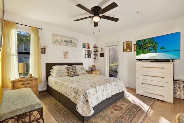 bedroom featuring access to outside, tile patterned flooring, and a ceiling fan