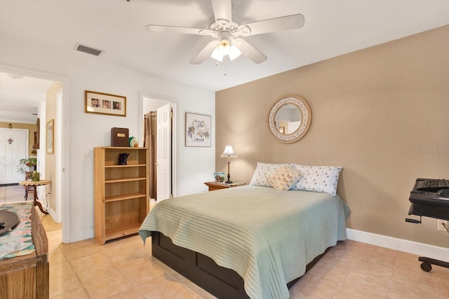 bedroom with a ceiling fan, visible vents, baseboards, and light tile patterned floors