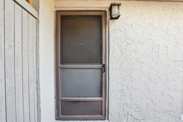 doorway to property featuring stucco siding