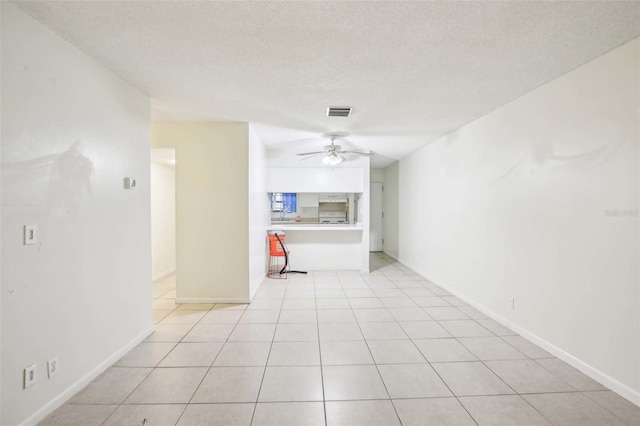 unfurnished room with visible vents, ceiling fan, a textured ceiling, and light tile patterned flooring