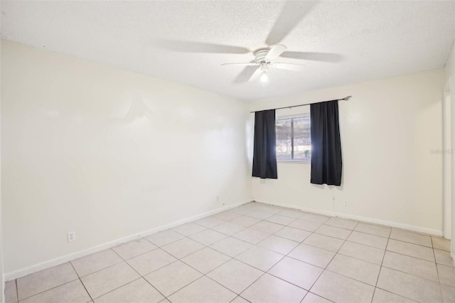 unfurnished room with ceiling fan, light tile patterned floors, a textured ceiling, and baseboards