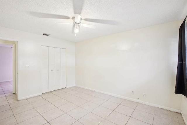 unfurnished bedroom featuring baseboards, a textured ceiling, visible vents, and a closet