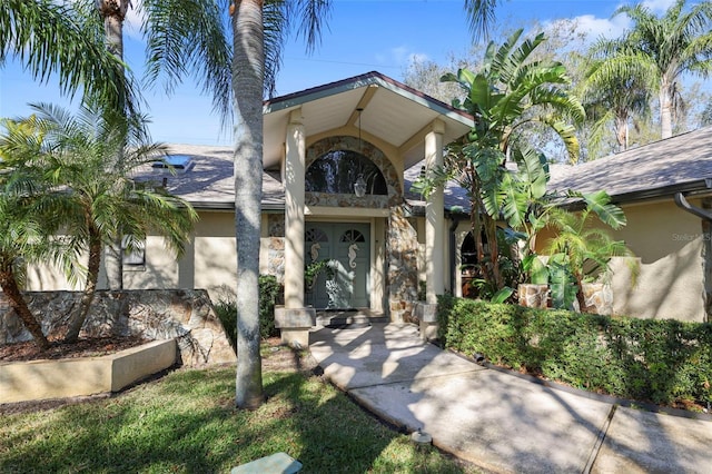 view of exterior entry with stone siding and stucco siding