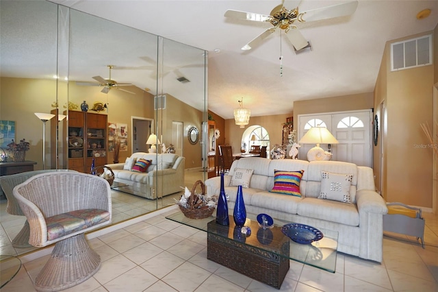 tiled living room with lofted ceiling, visible vents, and a ceiling fan