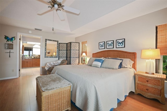 3416 Fairfield Trl, Clearwater, FL 33761 - bedroom with baseboards, visible vents, a raised ceiling, wood finished floors, and ensuite bathroom