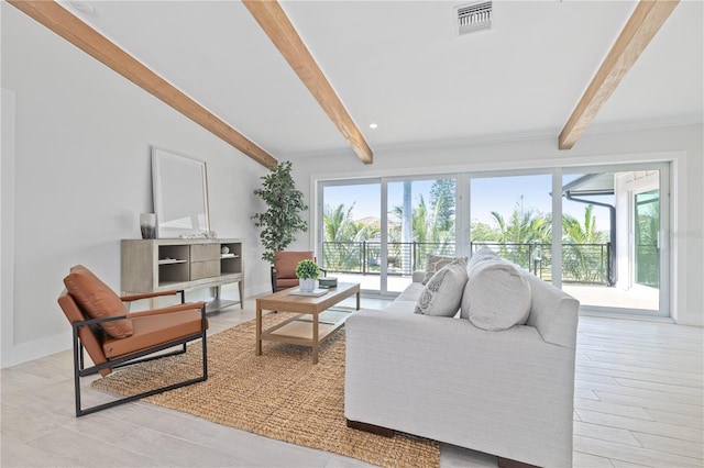 living room featuring vaulted ceiling with beams, plenty of natural light, and visible vents