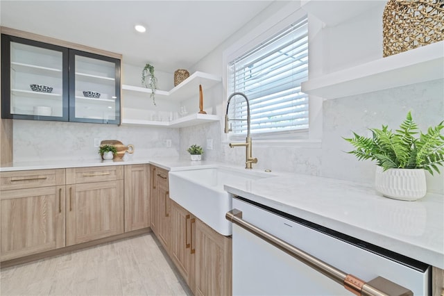 kitchen with a sink, light countertops, dishwasher, light brown cabinetry, and tasteful backsplash