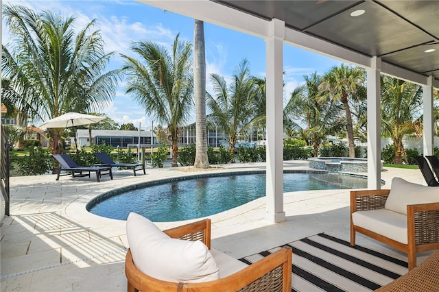 view of swimming pool featuring a pool with connected hot tub, an outdoor hangout area, and a patio