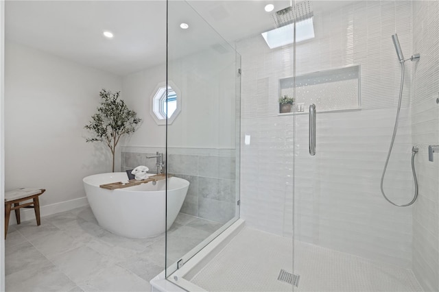 full bathroom featuring a stall shower, baseboards, marble finish floor, and a freestanding tub