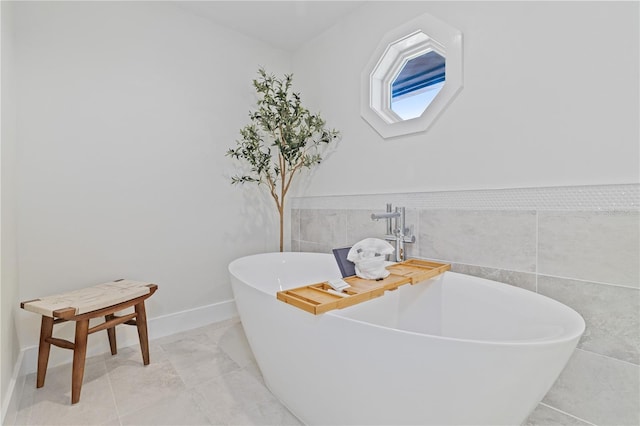 full bathroom featuring a freestanding tub and tile walls