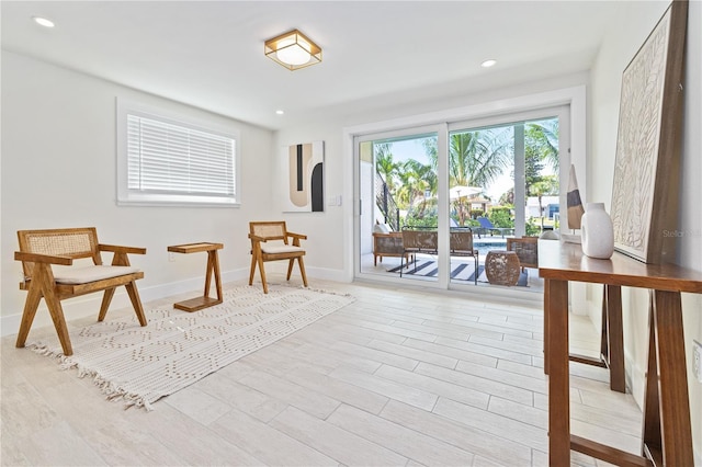 living area featuring light wood-style floors, recessed lighting, and baseboards