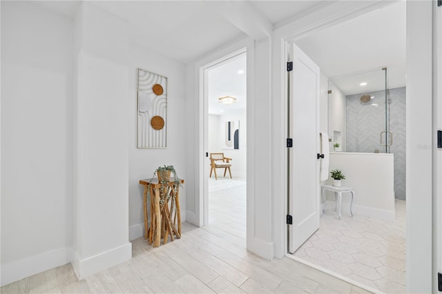 hallway featuring wood finished floors and baseboards