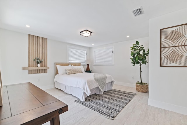 bedroom with recessed lighting, wood finished floors, visible vents, and baseboards