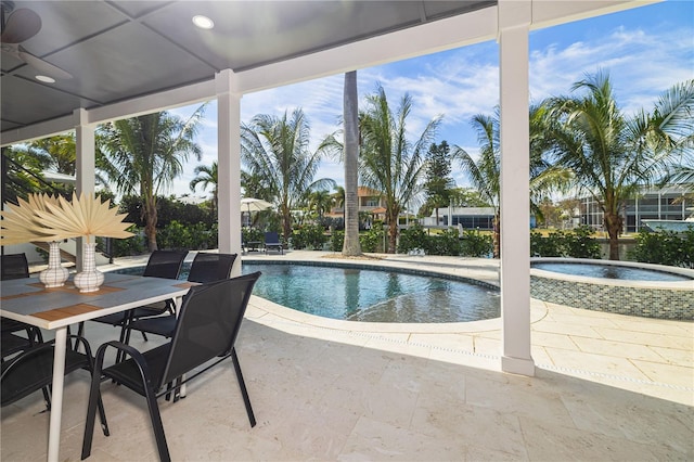 outdoor pool with a patio area, outdoor dining space, and an in ground hot tub