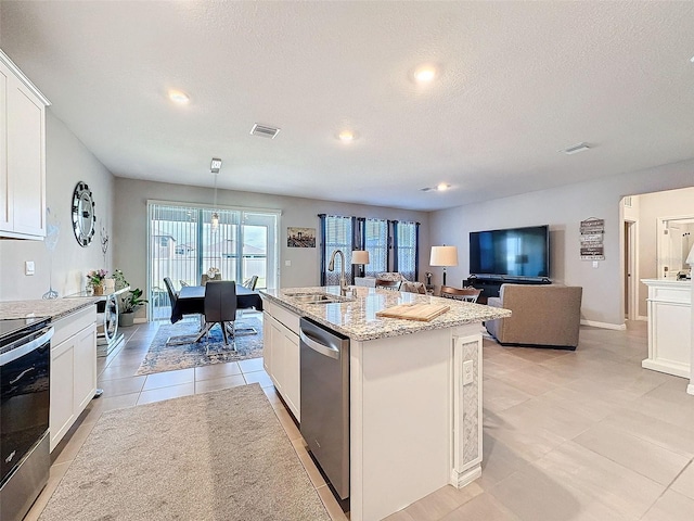 kitchen featuring a sink, visible vents, white cabinetry, appliances with stainless steel finishes, and light stone countertops