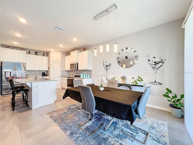 dining area with light tile patterned floors, baseboards, visible vents, and recessed lighting