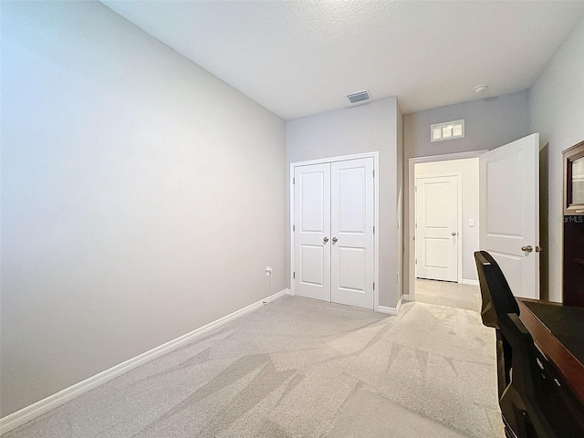 unfurnished office featuring light carpet, visible vents, and baseboards