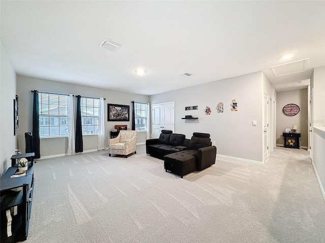 living room featuring visible vents, baseboards, attic access, and light colored carpet