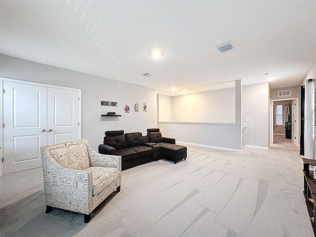 living room with carpet, visible vents, and baseboards