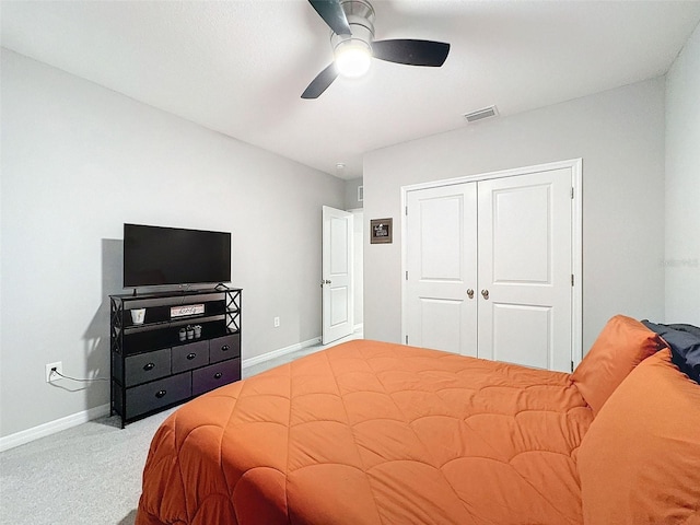 carpeted bedroom featuring ceiling fan, a closet, visible vents, and baseboards