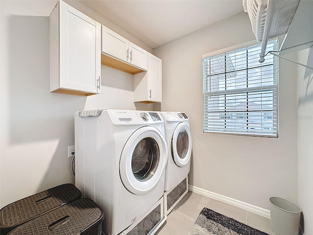 clothes washing area featuring light tile patterned floors, independent washer and dryer, cabinet space, and baseboards