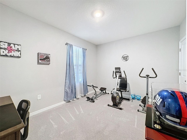 workout area featuring a textured ceiling and baseboards