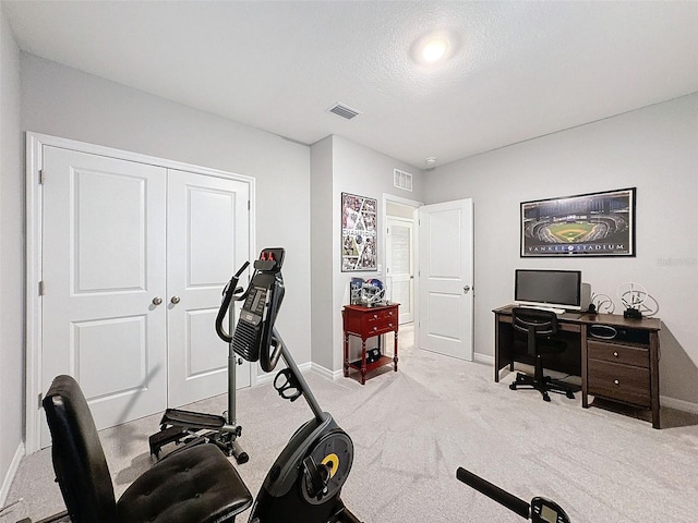 exercise room with carpet, visible vents, a textured ceiling, and baseboards