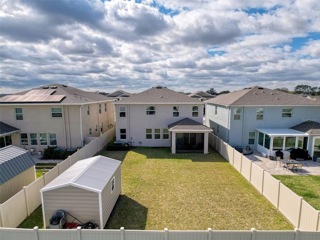 back of house featuring a yard, a patio area, a fenced backyard, and stucco siding