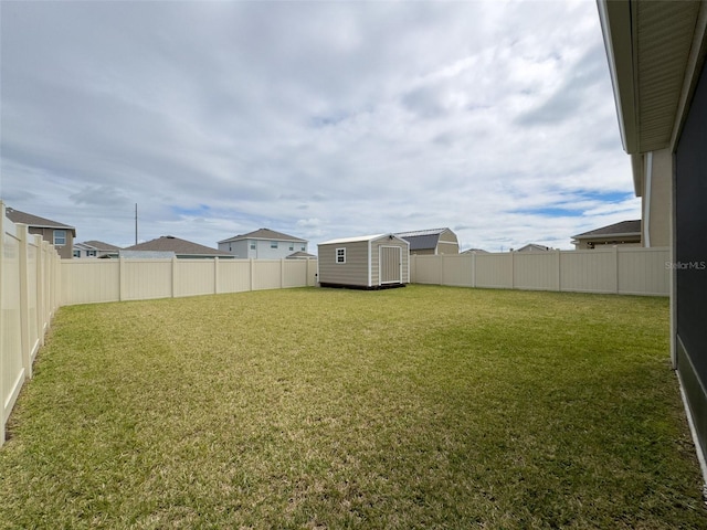 view of yard featuring a storage shed, an outbuilding, and a fenced backyard