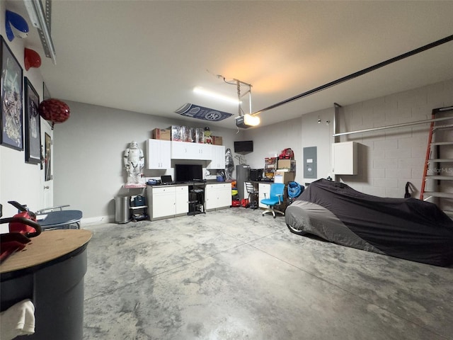 garage with concrete block wall, electric panel, and a garage door opener