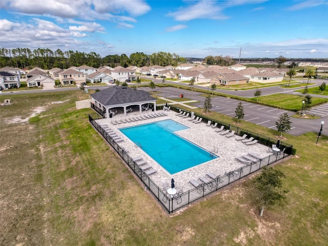 community pool featuring a gazebo, fence, and a residential view