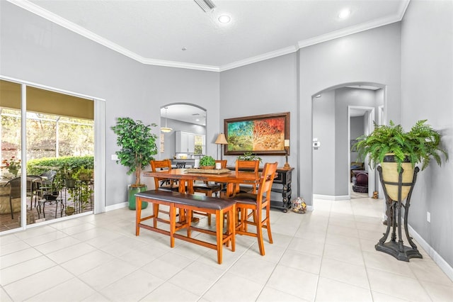 dining space featuring arched walkways, plenty of natural light, and ornamental molding