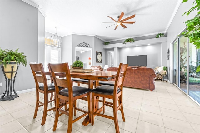 dining space with light tile patterned floors, baseboards, ornamental molding, and a ceiling fan