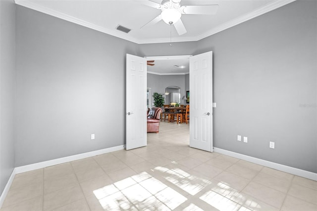 spare room with visible vents, ornamental molding, light tile patterned flooring, baseboards, and ceiling fan