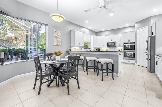 dining room with light tile patterned floors, a wealth of natural light, and ceiling fan