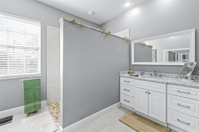 bathroom featuring vanity, baseboards, and tile patterned flooring