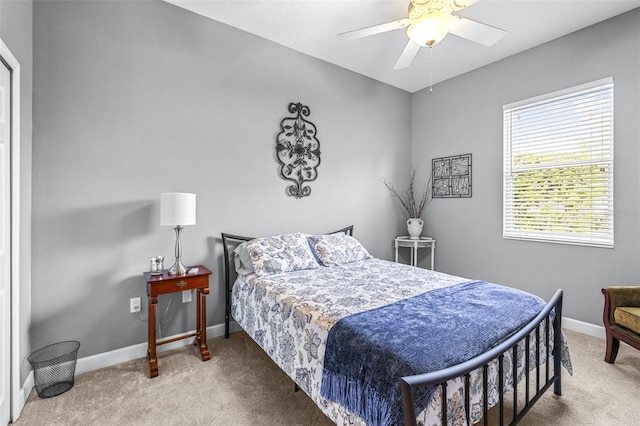 carpeted bedroom with ceiling fan and baseboards