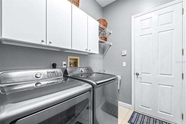 washroom featuring light tile patterned floors, baseboards, cabinet space, and washing machine and dryer