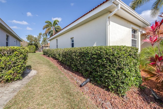 view of property exterior featuring a lawn and stucco siding