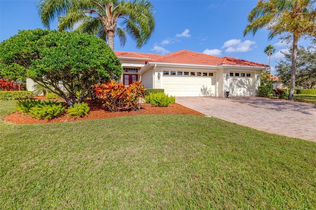 view of front facade featuring a front yard, driveway, stucco siding, a garage, and a tile roof