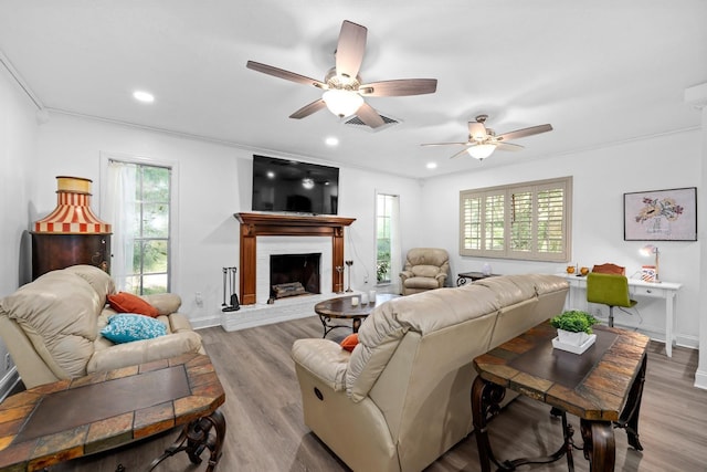 living room featuring baseboards, a brick fireplace, wood finished floors, and recessed lighting