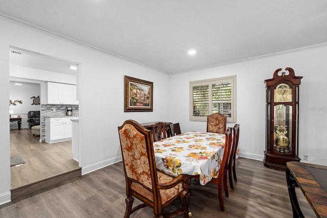 dining room featuring recessed lighting, baseboards, crown molding, and wood finished floors