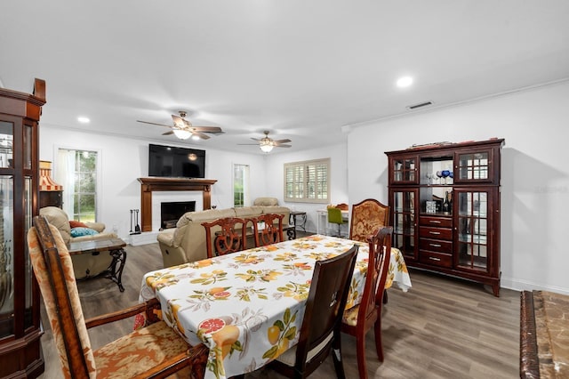 dining area with baseboards, visible vents, wood finished floors, a fireplace, and recessed lighting