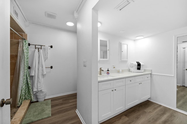 full bath with visible vents, a wainscoted wall, wood finished floors, curtained shower, and vanity