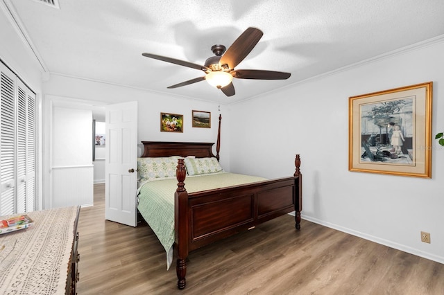 bedroom featuring a ceiling fan, crown molding, a textured ceiling, and wood finished floors