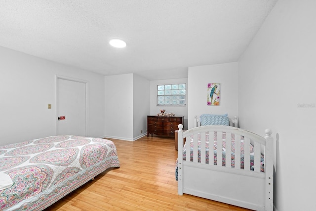 bedroom with light wood-style flooring and baseboards