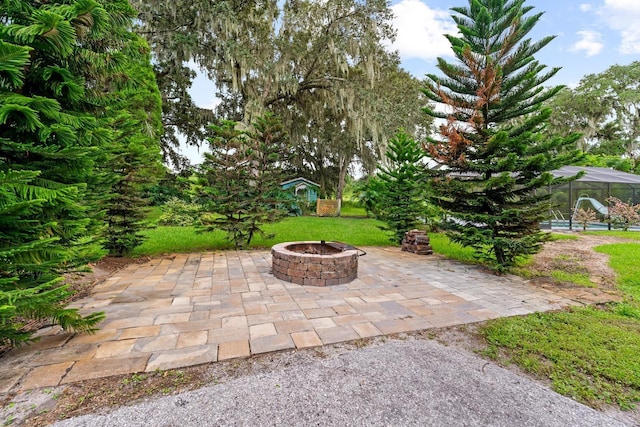 view of patio featuring an outdoor fire pit and a lanai