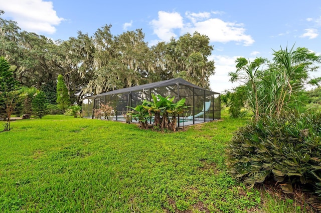 view of yard with glass enclosure and an outdoor pool